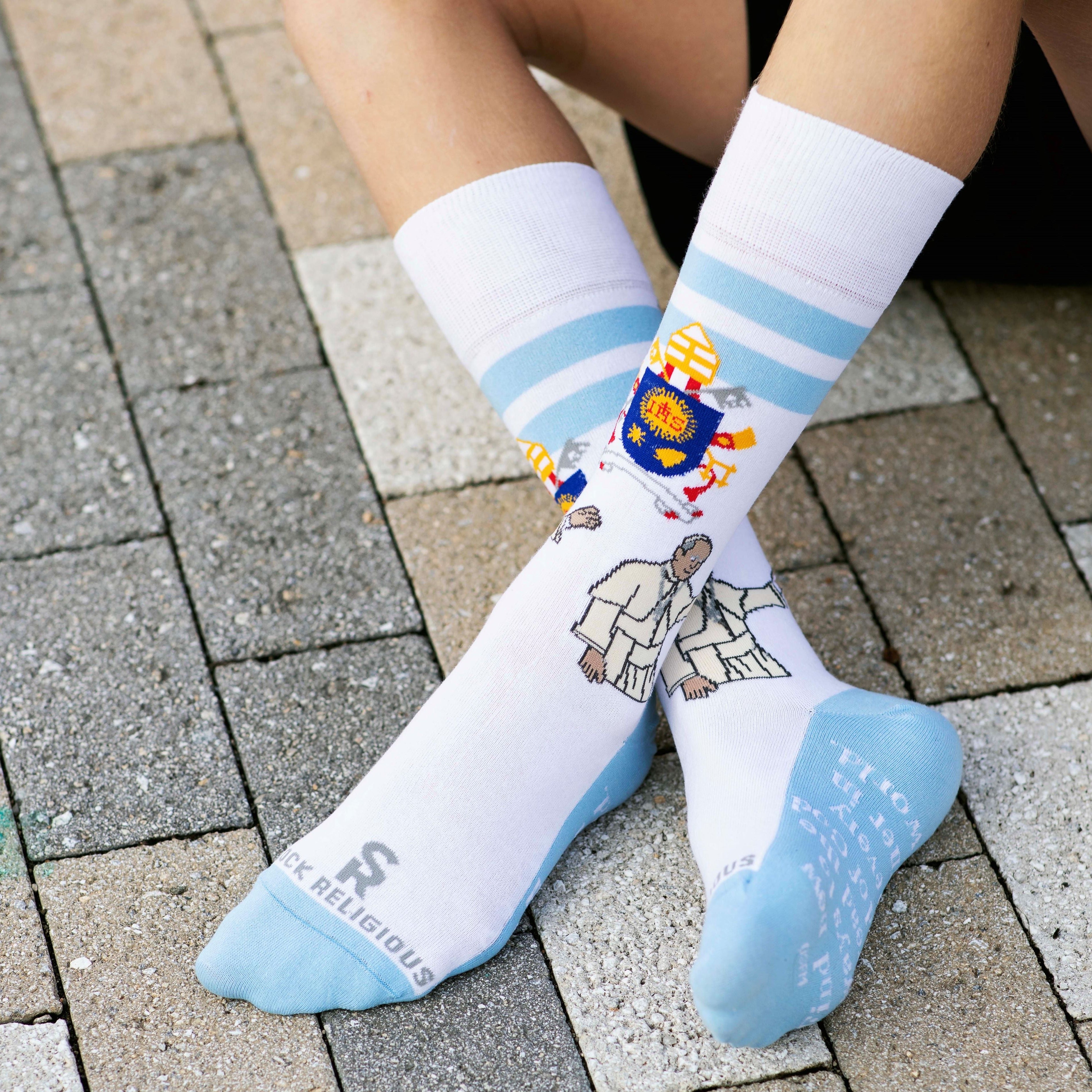 a close up of a person wearing a pair of socks with a picture of Pope Francis