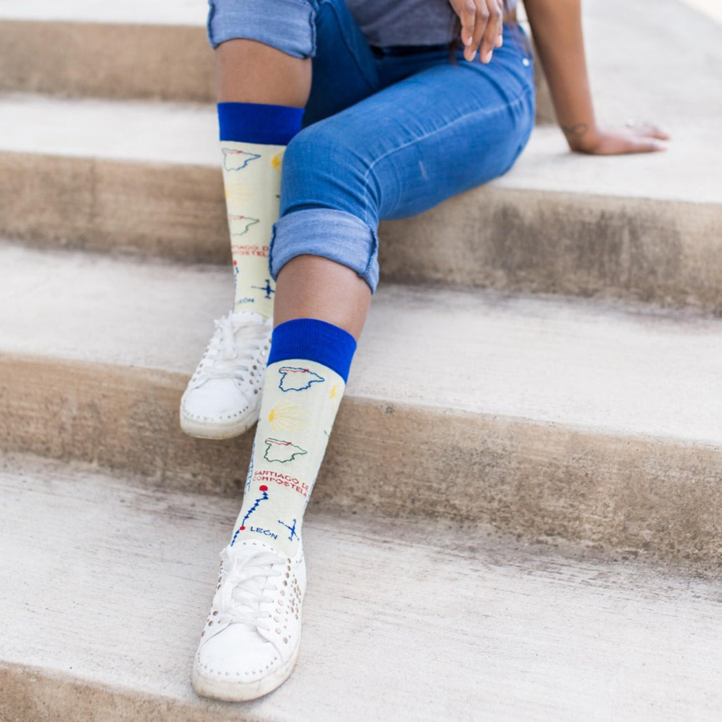 a woman sitting on the steps with her feet up wearing a pair of blue and white socks with a map on them