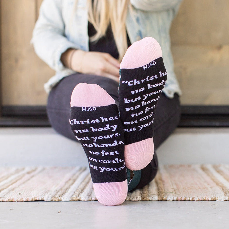 a woman sitting on the floor with her feet up wearing St. Teresa of Avila socks
