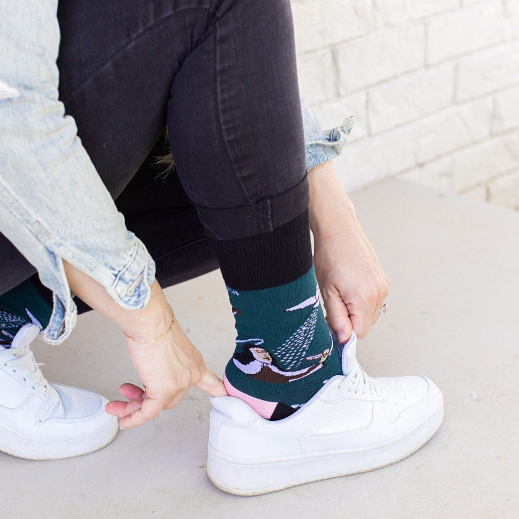 a woman wearing her shoes with a pair of white sneakers and St. Teresa of Avila socks