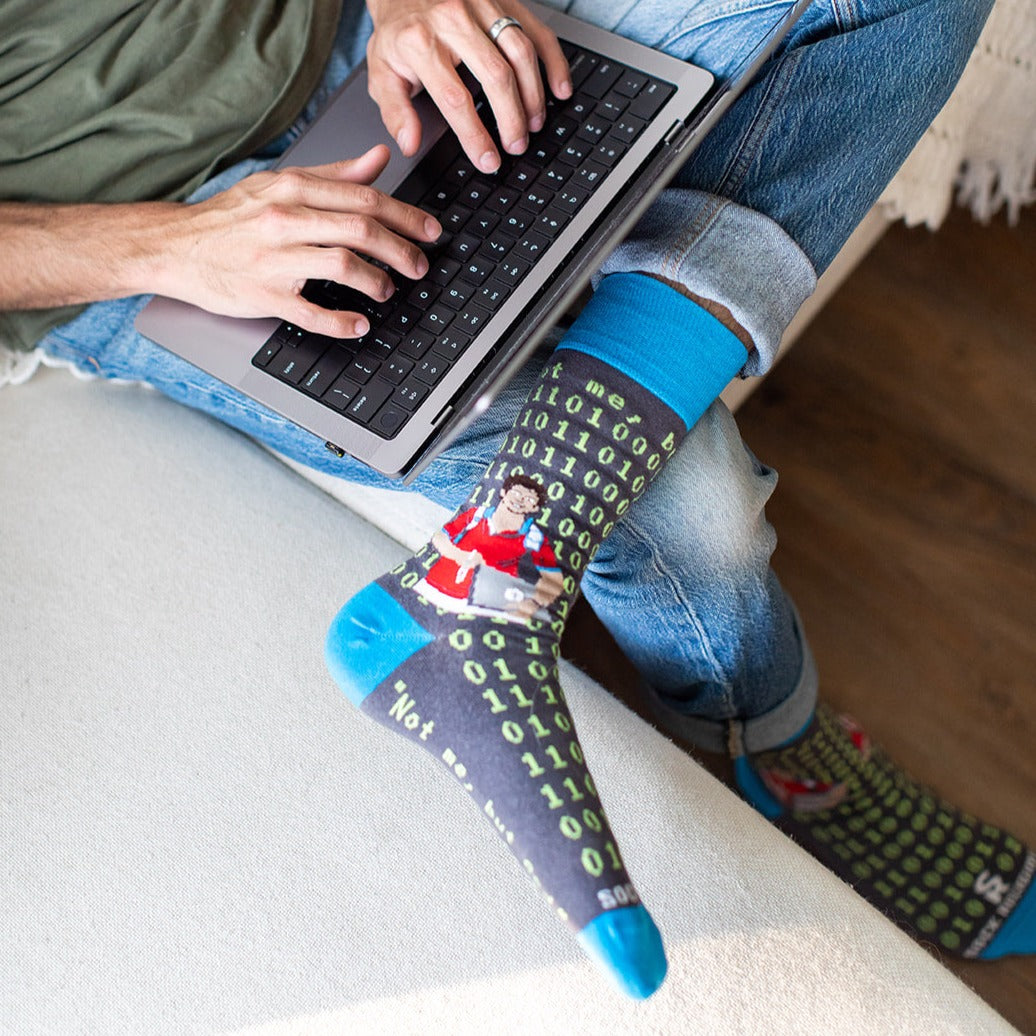a person sitting on a couch using a laptop