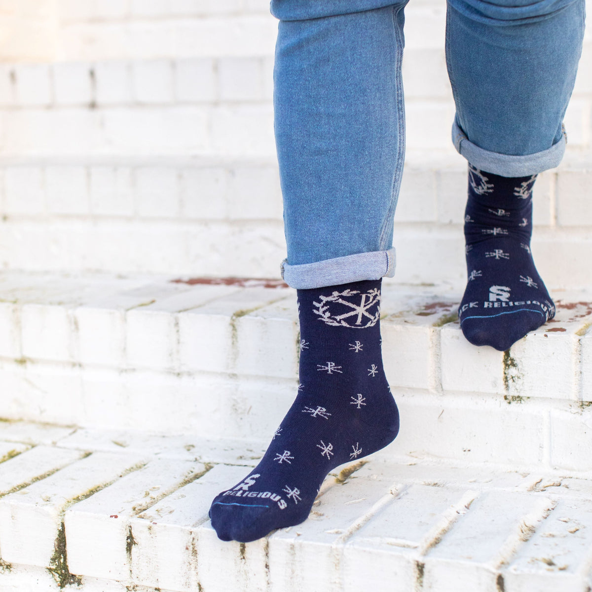 A person standing on steps wearing A pair of blue socks with a deign on it