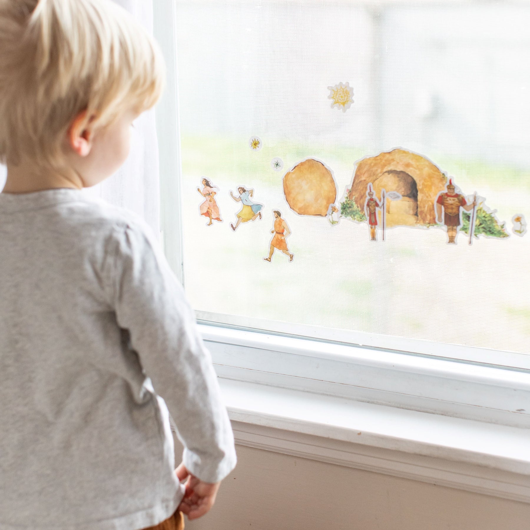 little boy looking at Close up of empty tomb cling set on a window