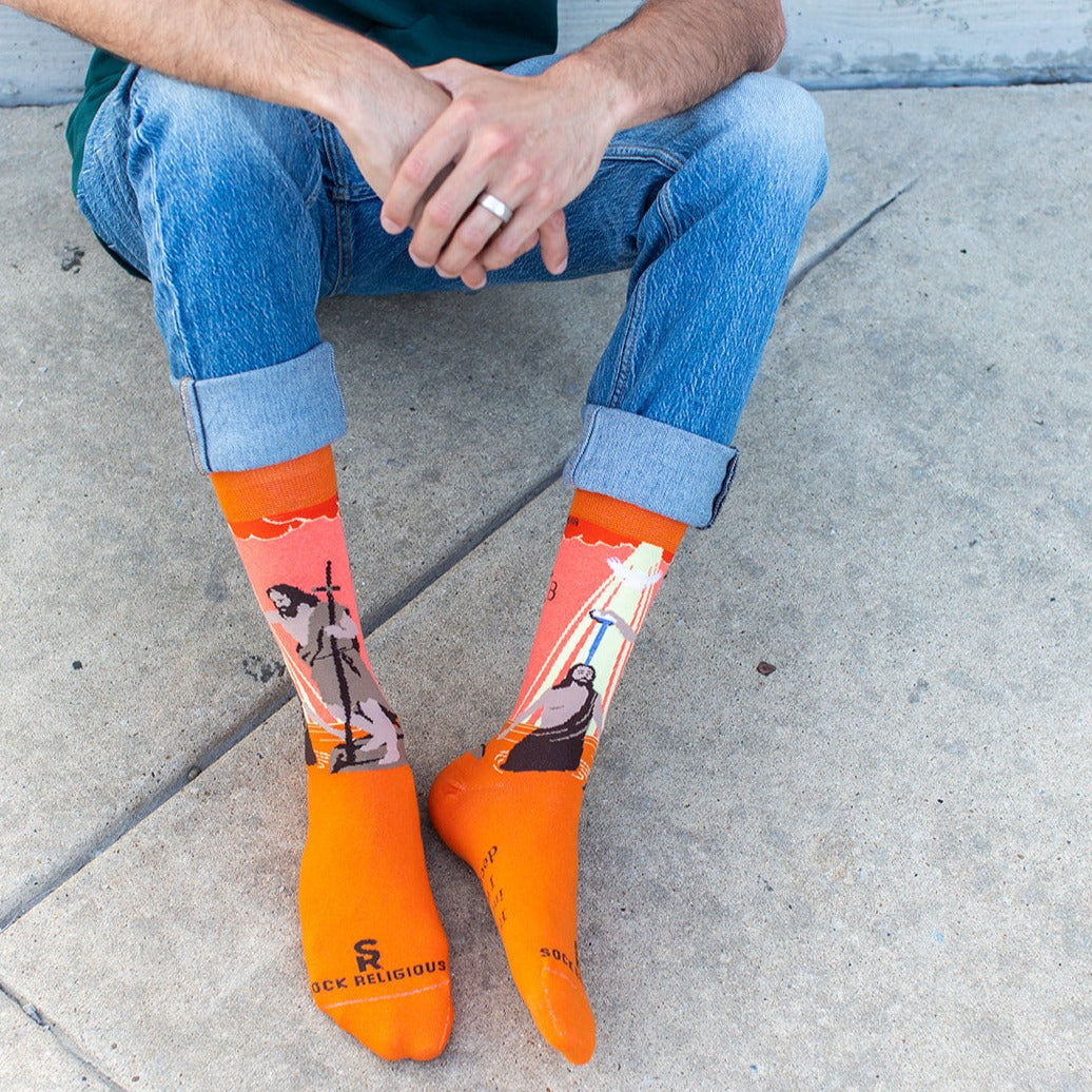 a man sitting on the ground wearing orange socks