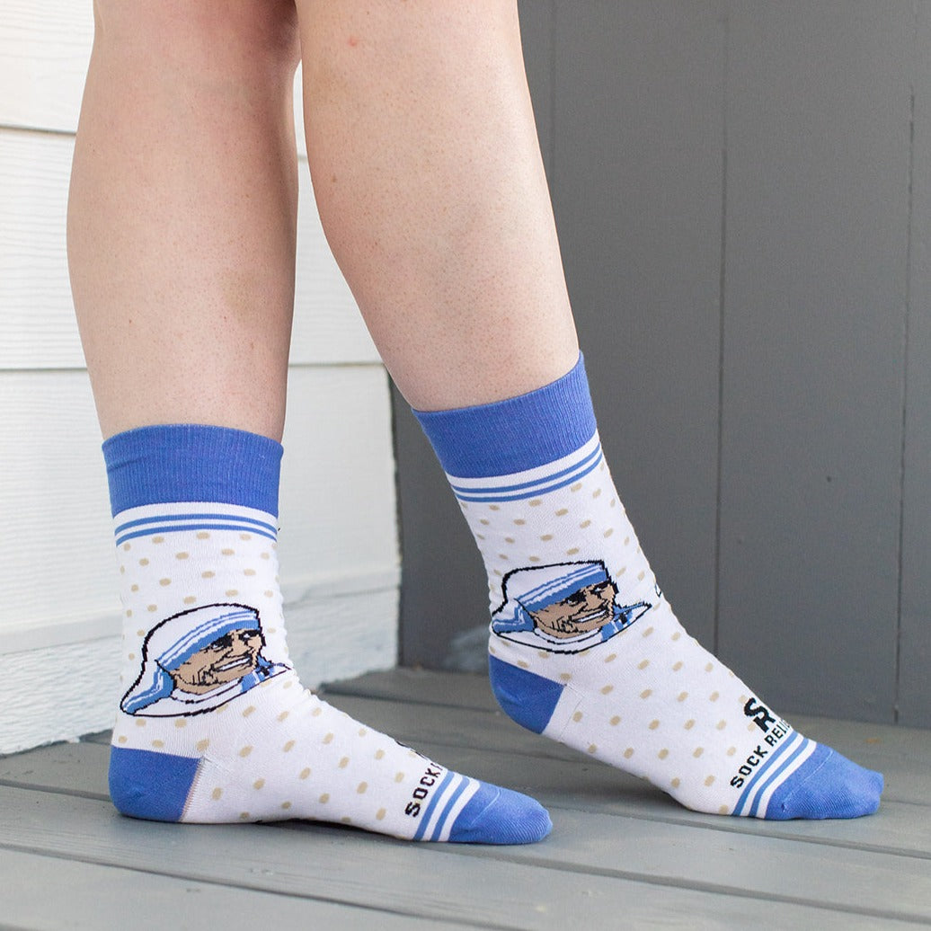 a close up of a person's legs wearing a pair of blue and white socks with a picture of a man wearing a hat