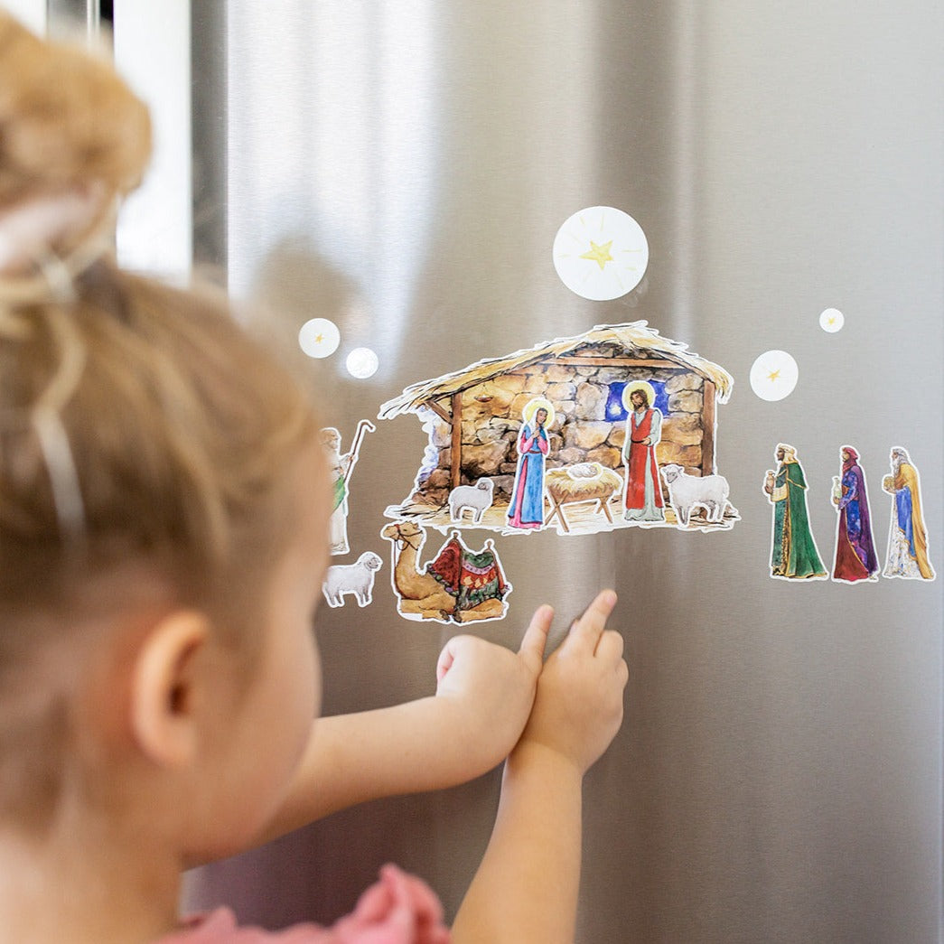 close up of little girls playing with Nativity Cling set on a fridge