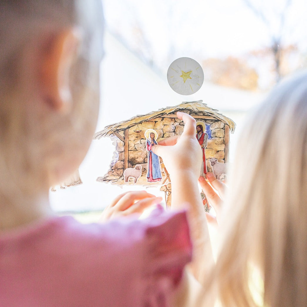 close up of little girls playing with Nativity Cling set on a window