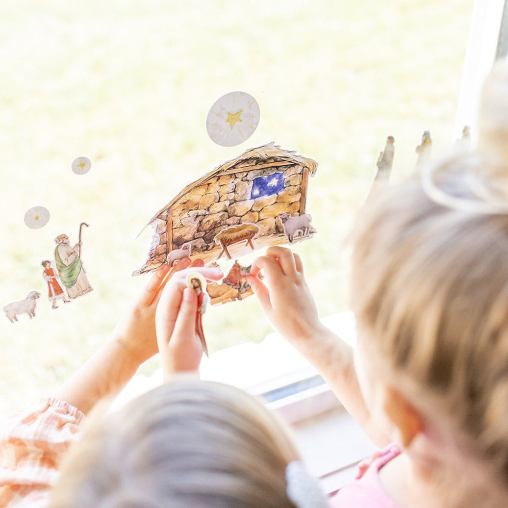 close up of little girls playing with Nativity Cling set on a window