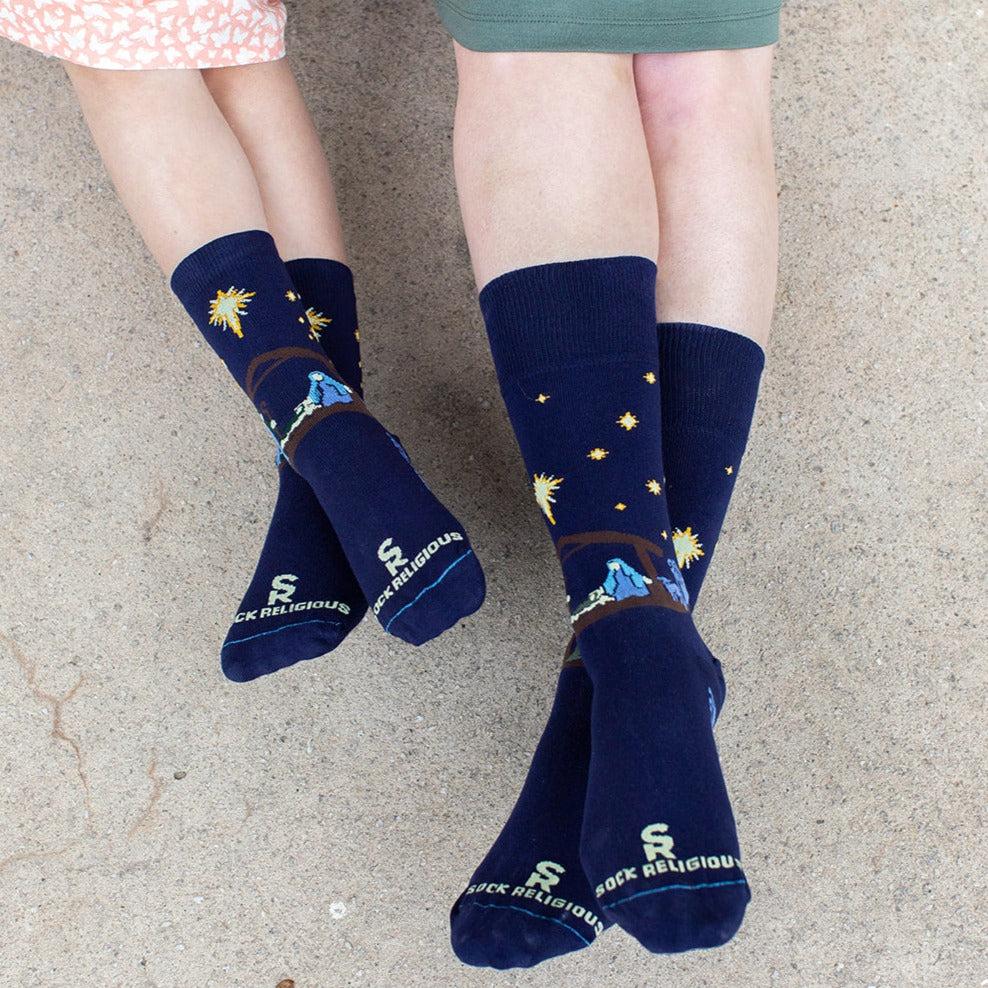 girl and mom sitting wearing dark navy blue socks featuring simple silhouettes of the manger scene
