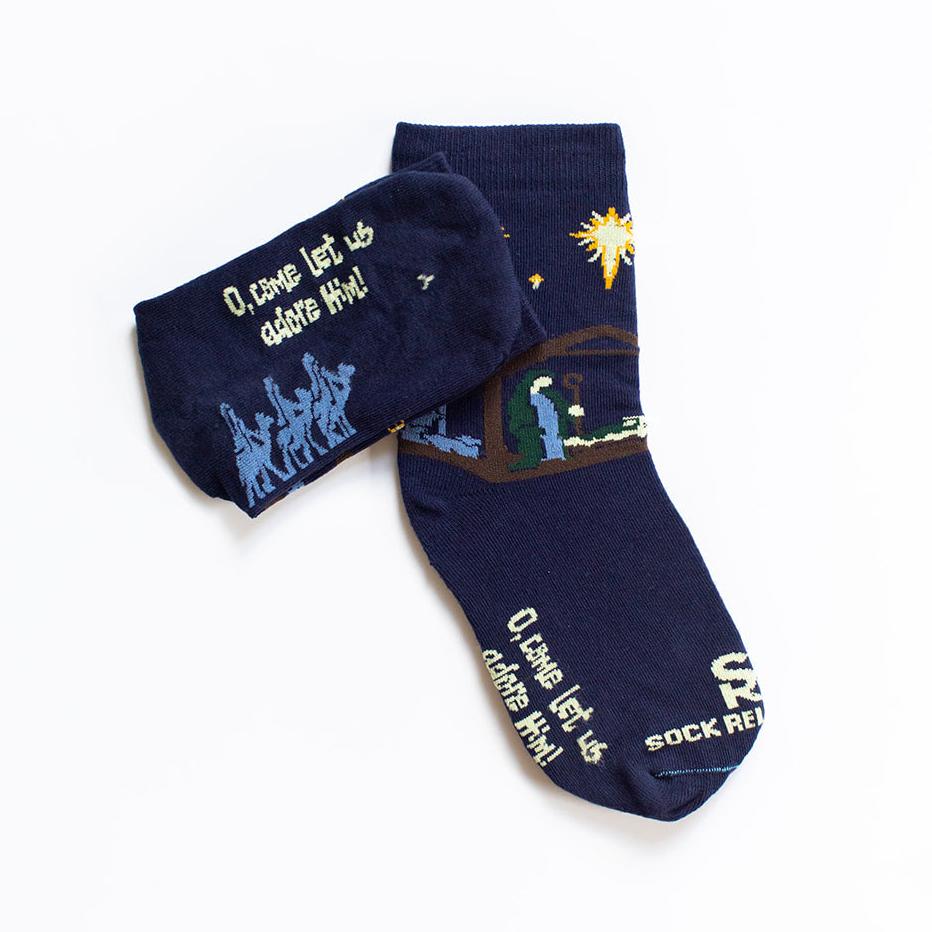 dark navy blue socks featuring simple silhouettes of the manger scene flat lay