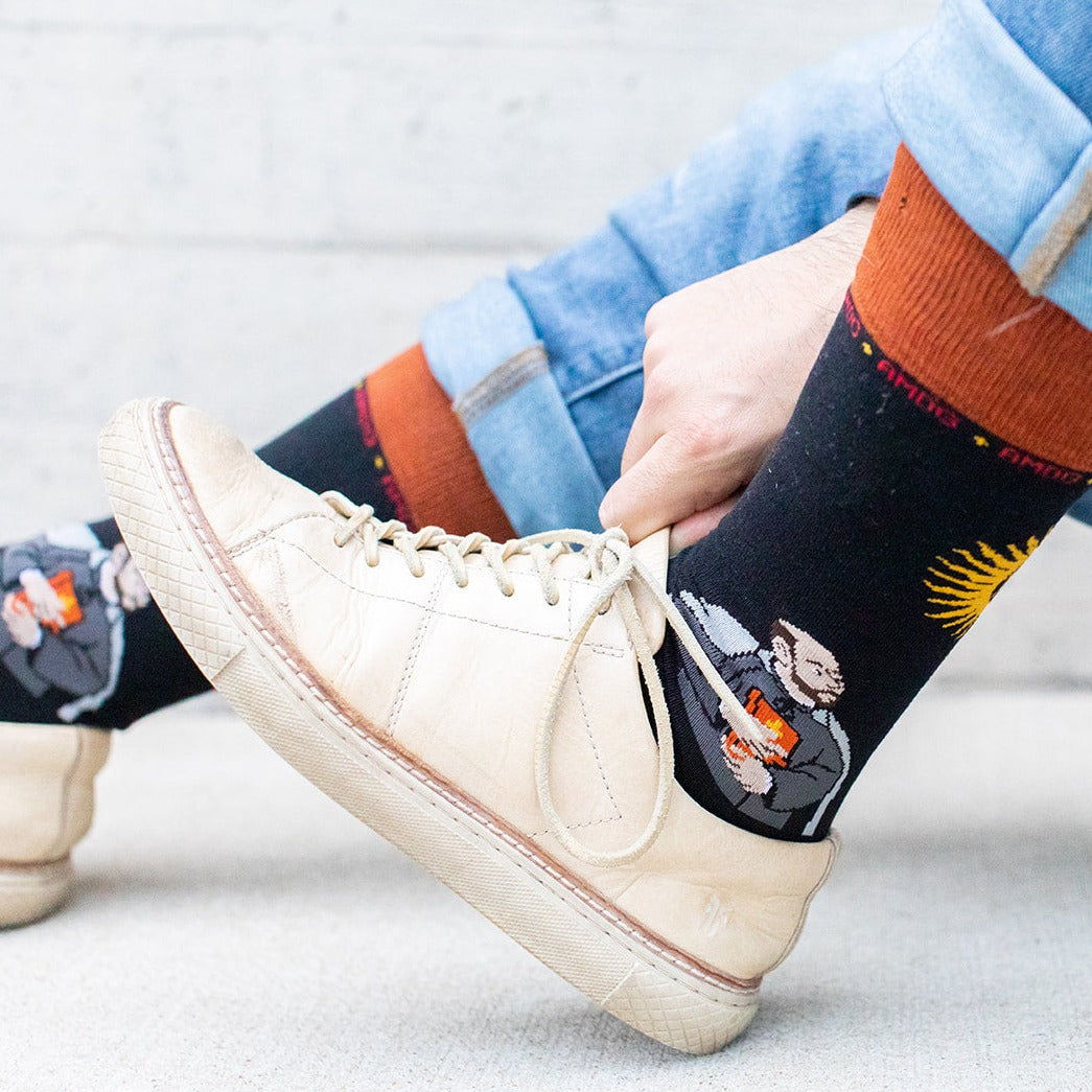 a person wearing a pair of white sneakers and wearing a pair of socks with a picture of a man on it