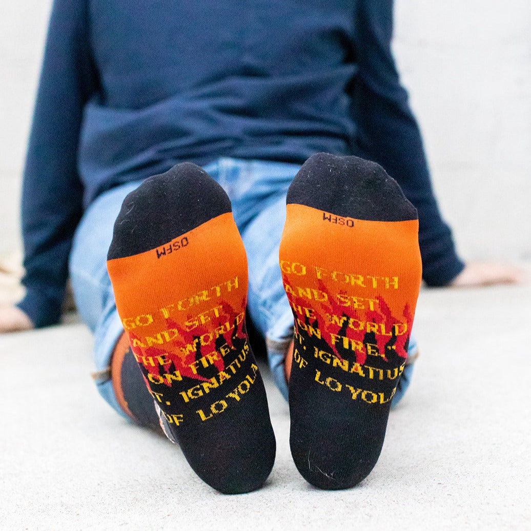 a person sitting on the ground with their feet up wearing a pair of socks with a picture of a man on it