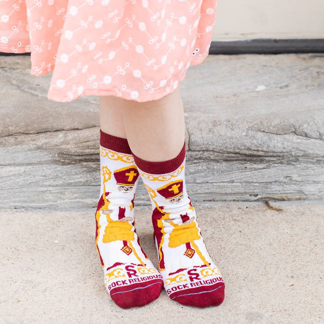 girl standing wearing white socks featuring large image of St. Nicholas the bishop