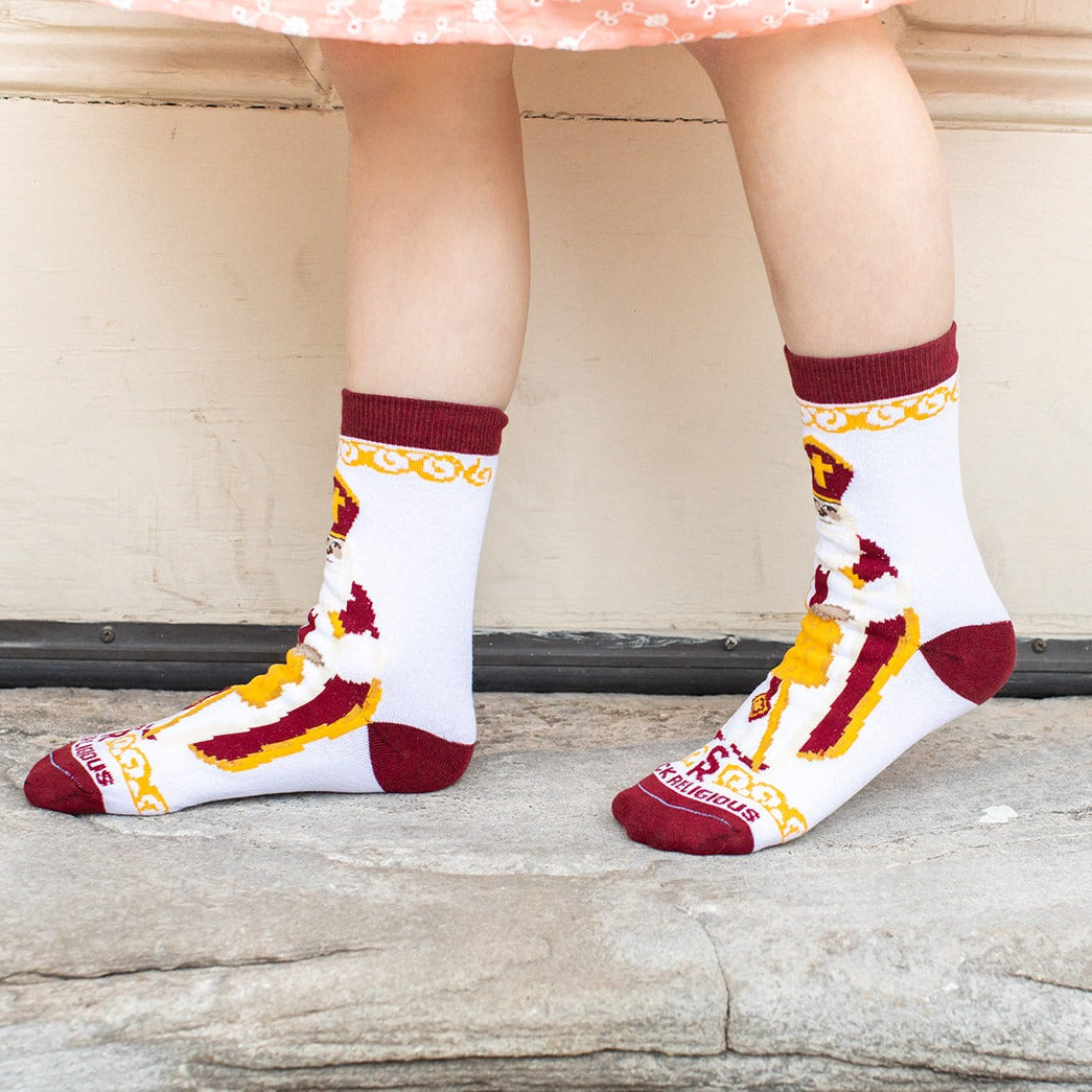 girl standing profile wearing white socks featuring large image of St. Nicholas the bishop