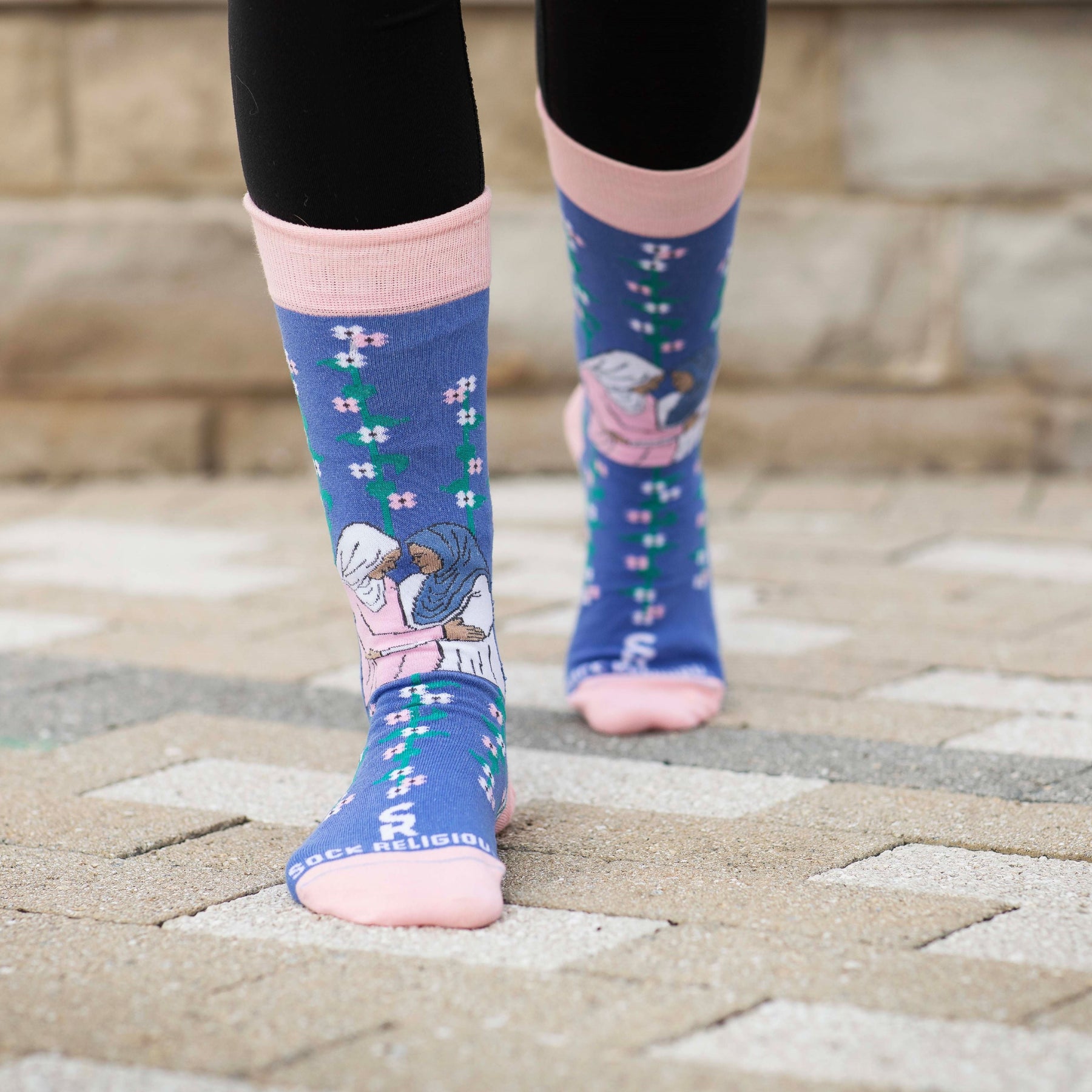 a close up of a person's feet wearing a pair of socks with a picture of Mary and Elizabeth