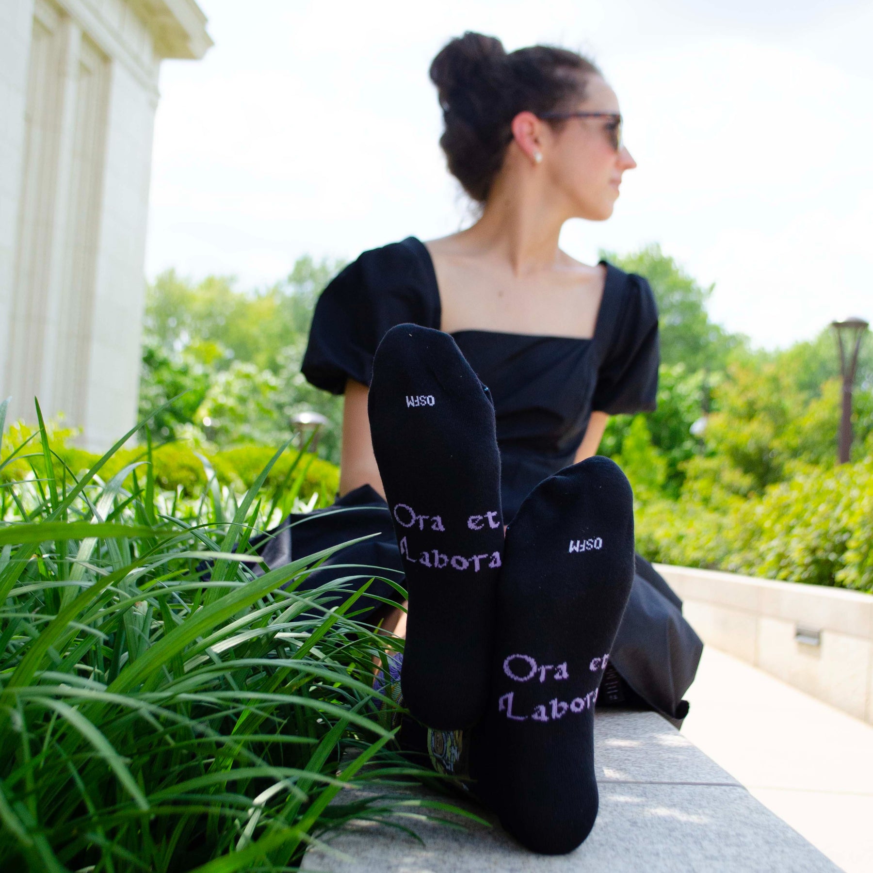 a woman sitting on a ledge with her feet up