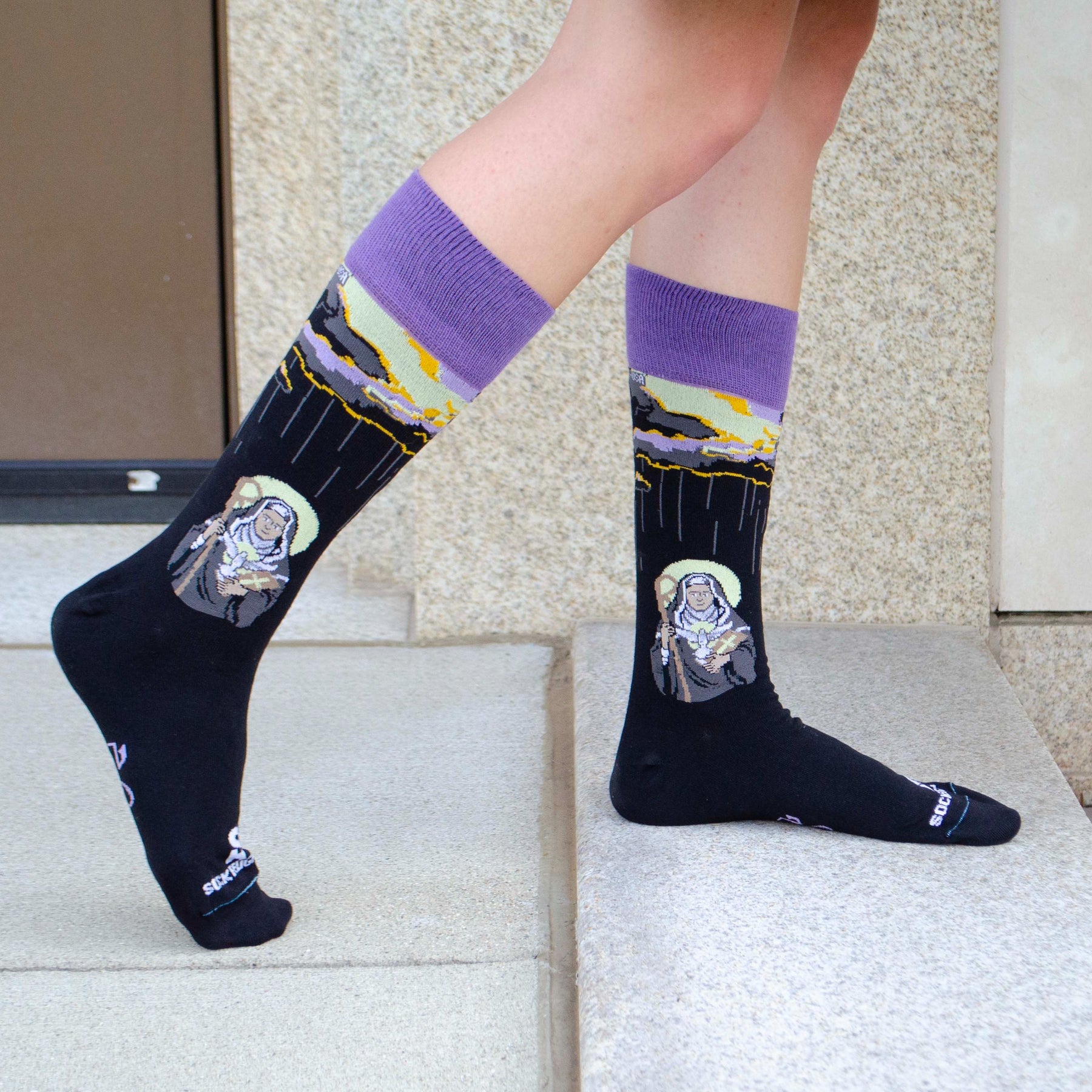 a person wearing socks with a picture of St. Scholastica