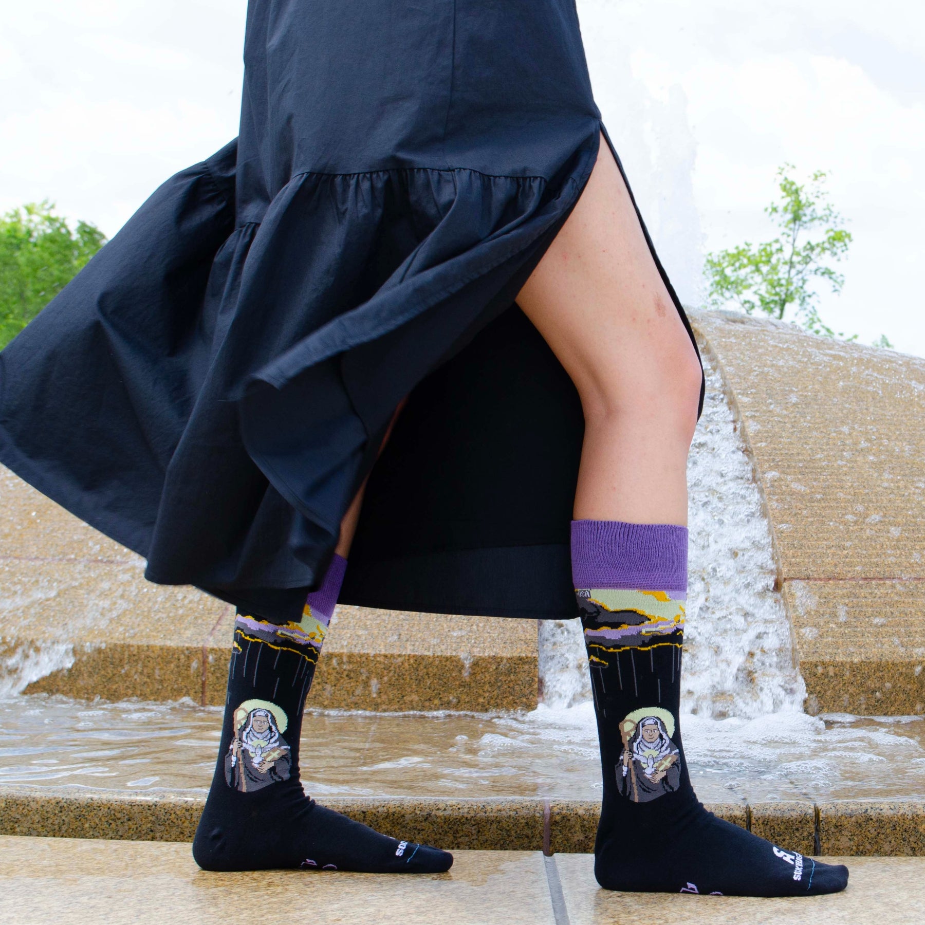 a woman in a skirt and socks standing in front of stairs