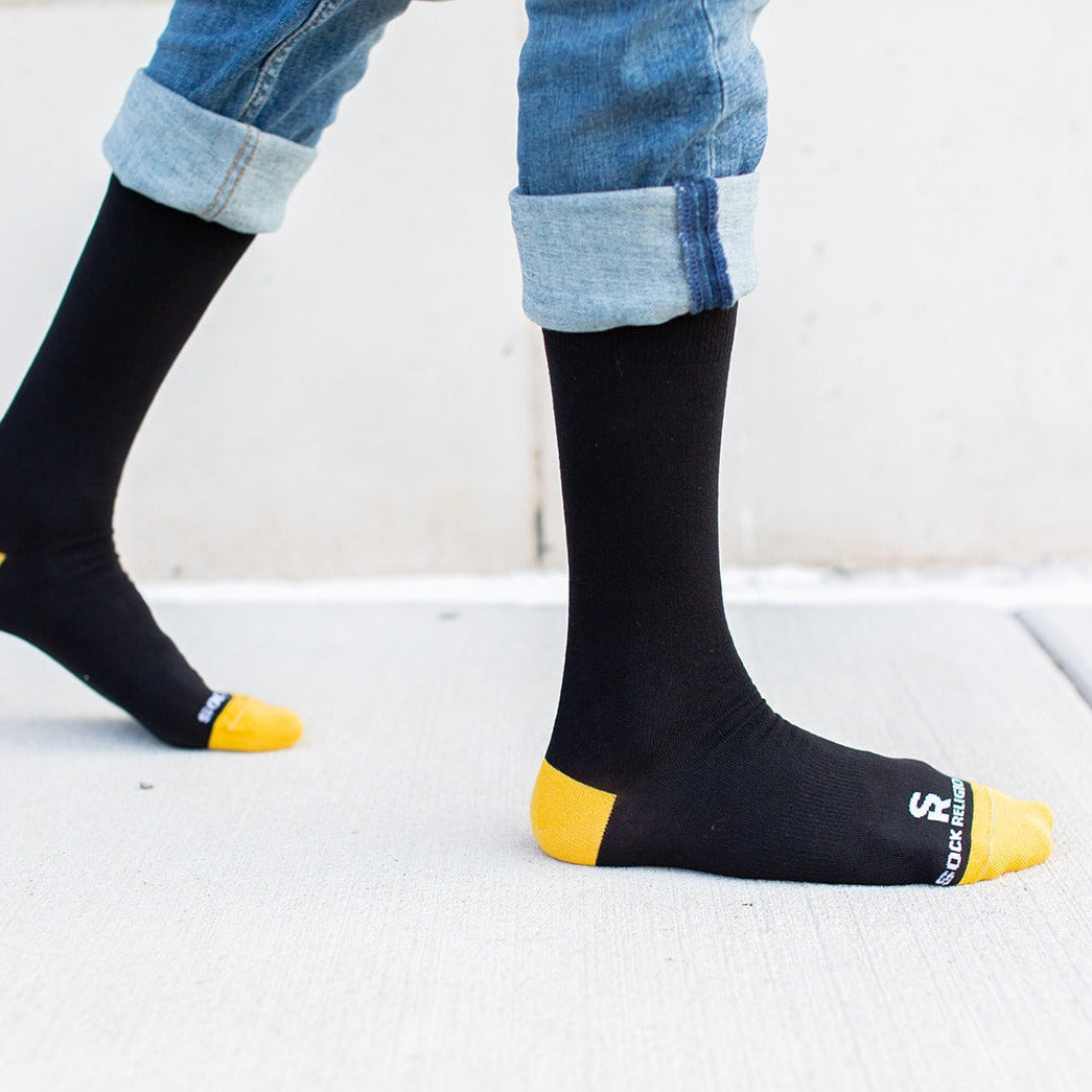 a person wearing a pair of black and yellow socks