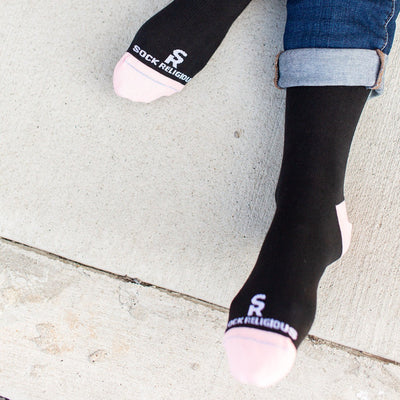 a person wearing a pair of black and pink socks