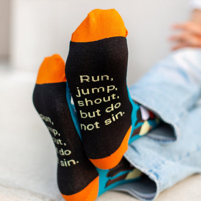 a pair of socks that say run, jump, shoot, but do not sin