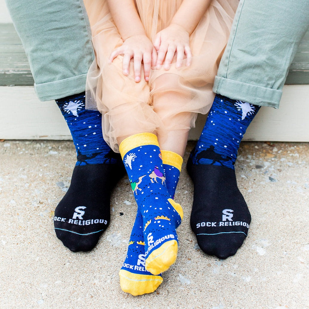 two person sitting on step wearing a pair of Three Wisemen socks with a picture of a star in the sky