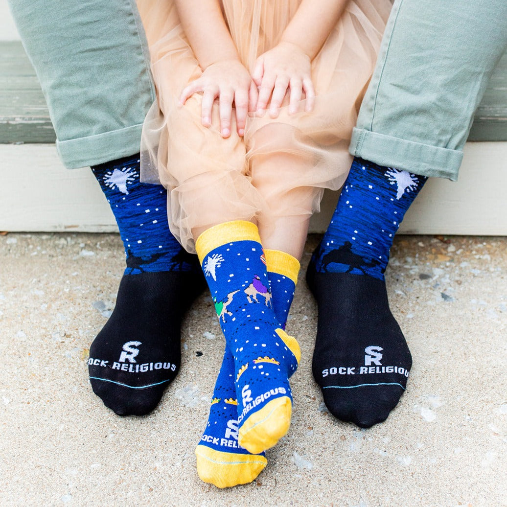 dad and daughter sitting wearing three wisemen adult xl and kids socks