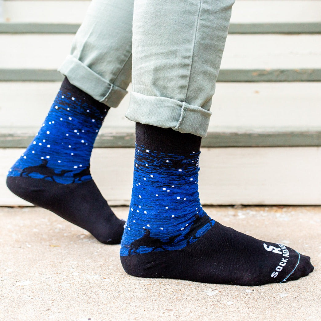 a person wearing a pair of Three Wisemen socks with a picture of a star in the sky