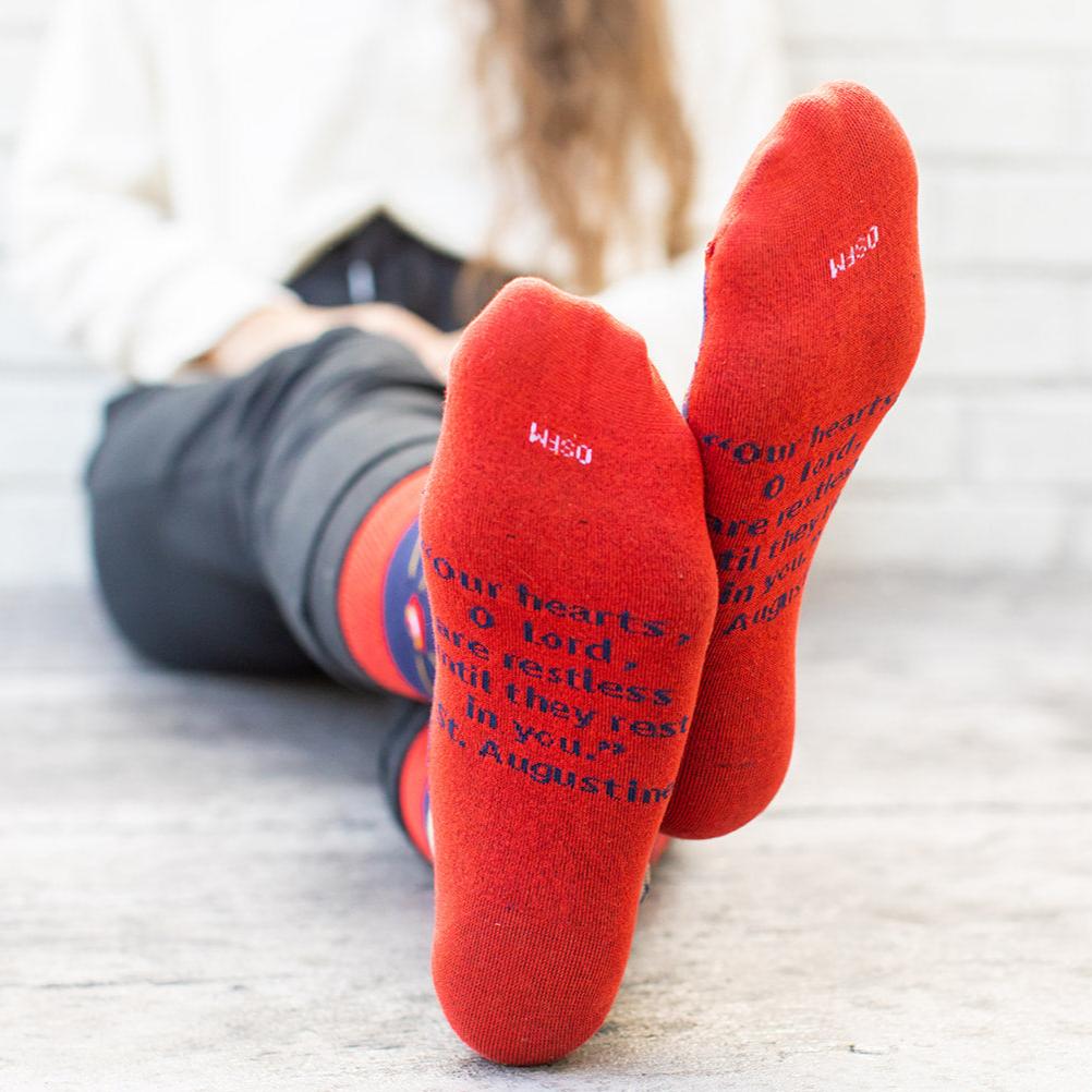 a woman sitting on the floor wearing red socks