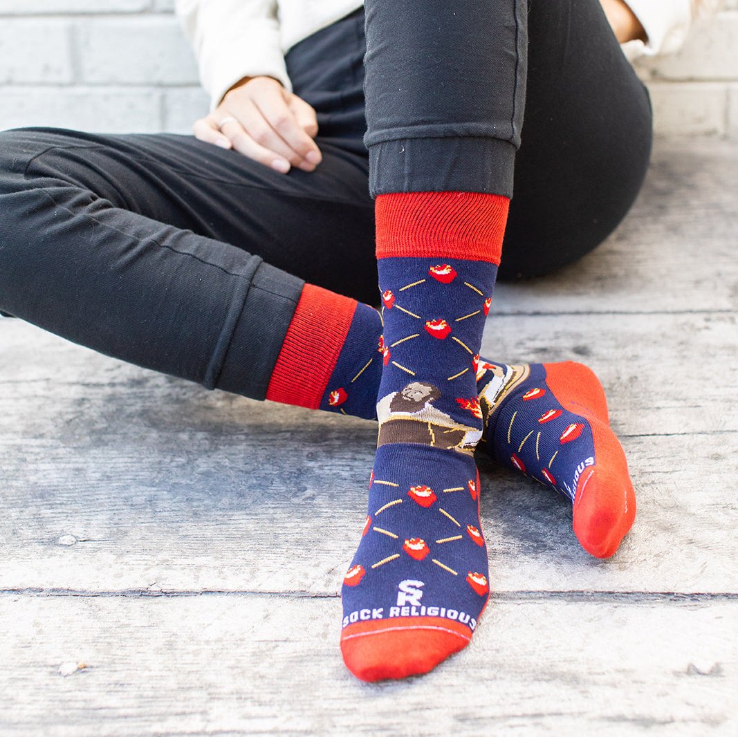 a person sitting on the ground wearing a pair of socks with a picture St. Augustine