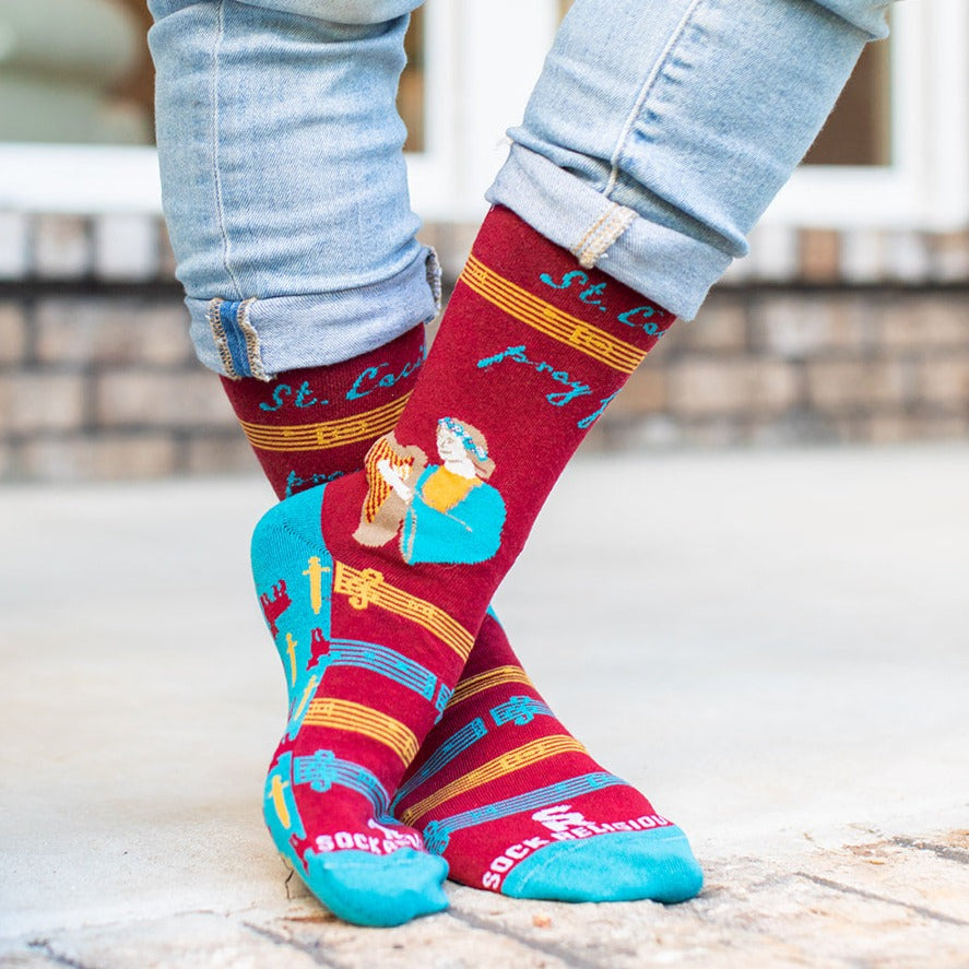 a person wearing a pair of socks with a picture of St. Cecilia
