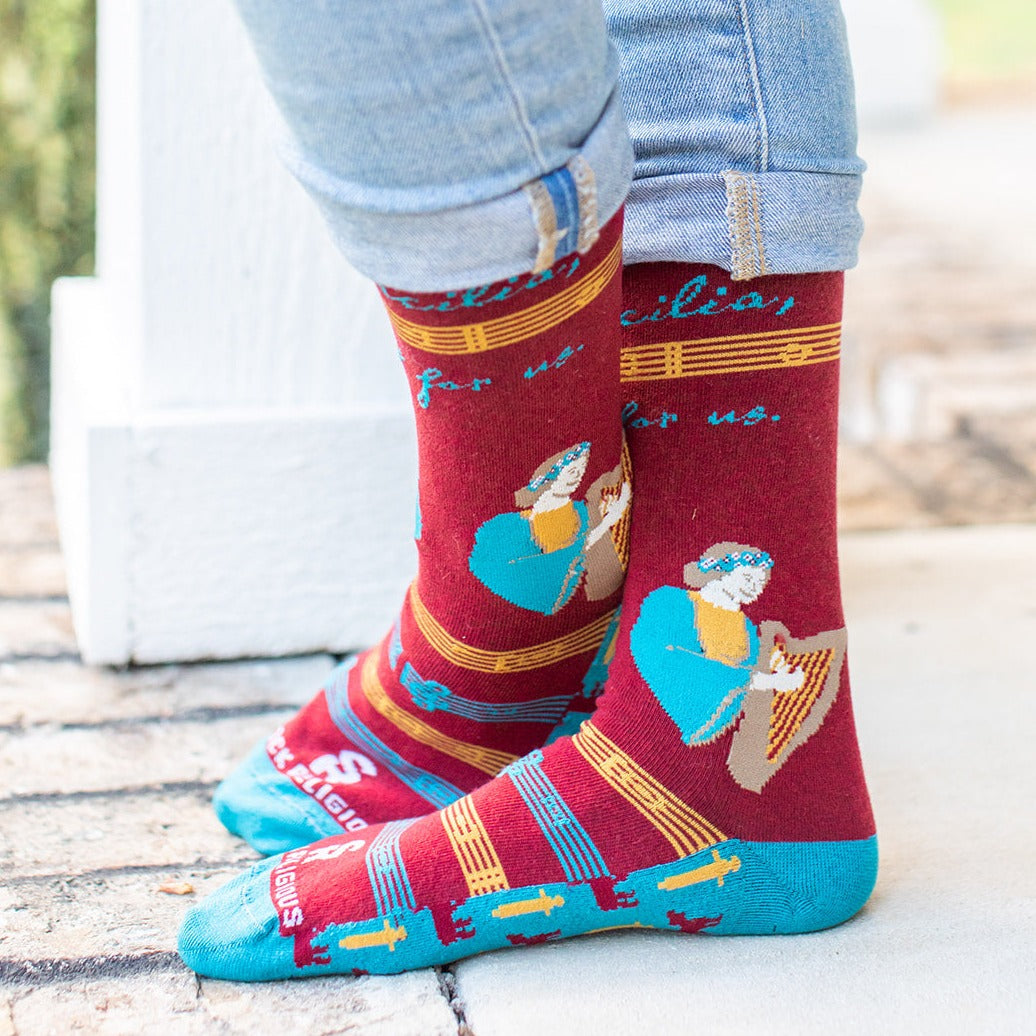 a person wearing a pair of socks with a picture of St. Cecilia