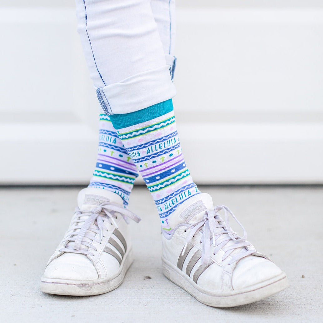 a close up of a person's feet wearing white shoes and colorful socks