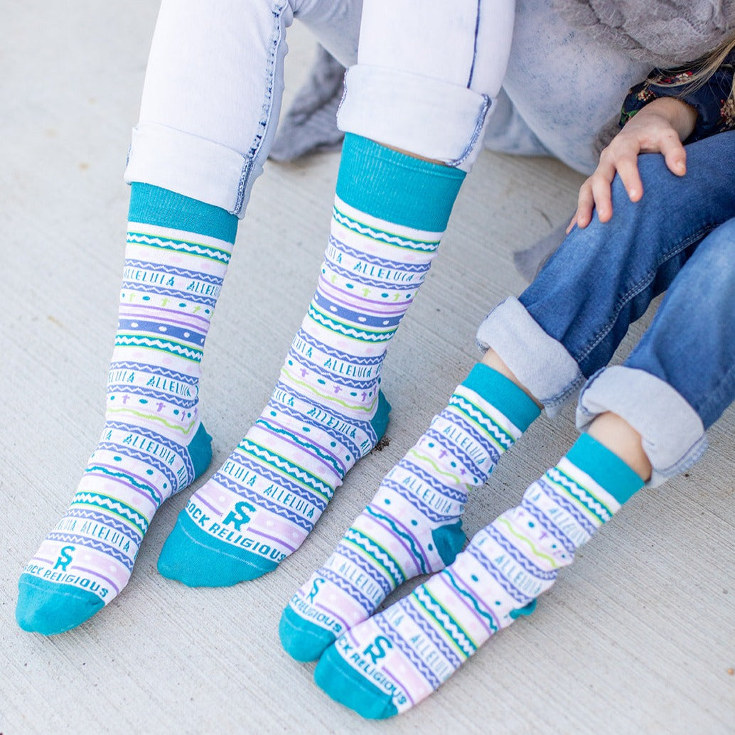 two person that are sitting on the ground wearing a pair of colorful socks