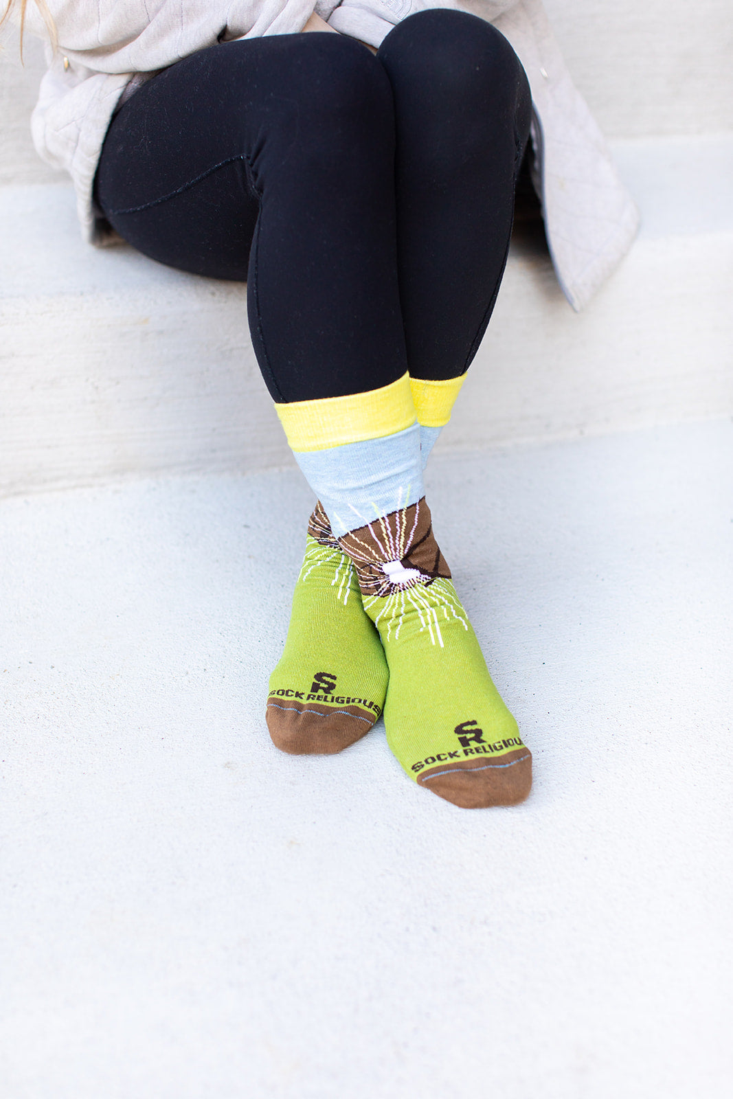 a woman sitting on the steps wearing a pair of socks with a picture of a mountain