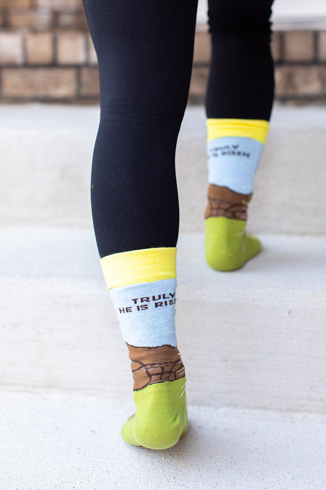 a person walking on steps wearing a pair of socks that say, truly he is risen