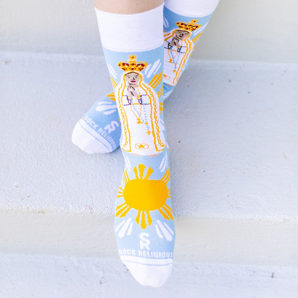 a person wearing a pair of socks with a picture of Our Lady Of Fatima