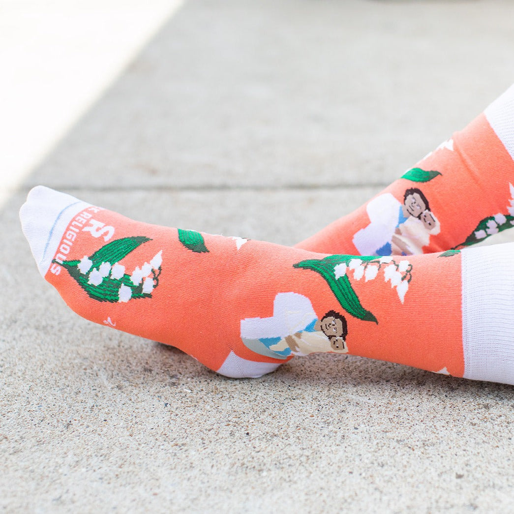 a close up of a person's feet wearing a pair of socks with a pricture of St. Gianna Molla