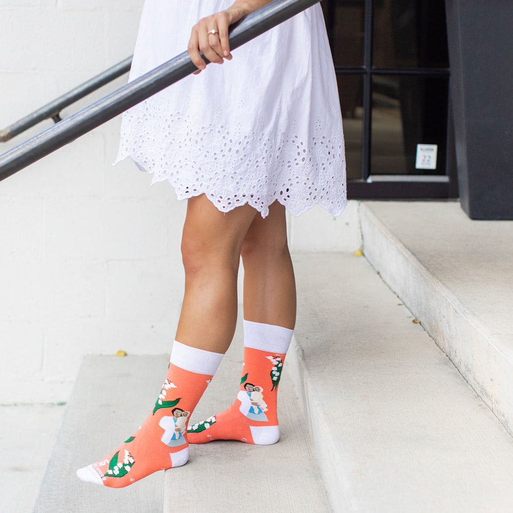 a woman on steps wearing a pair of socks with a pricture of St. Gianna Molla