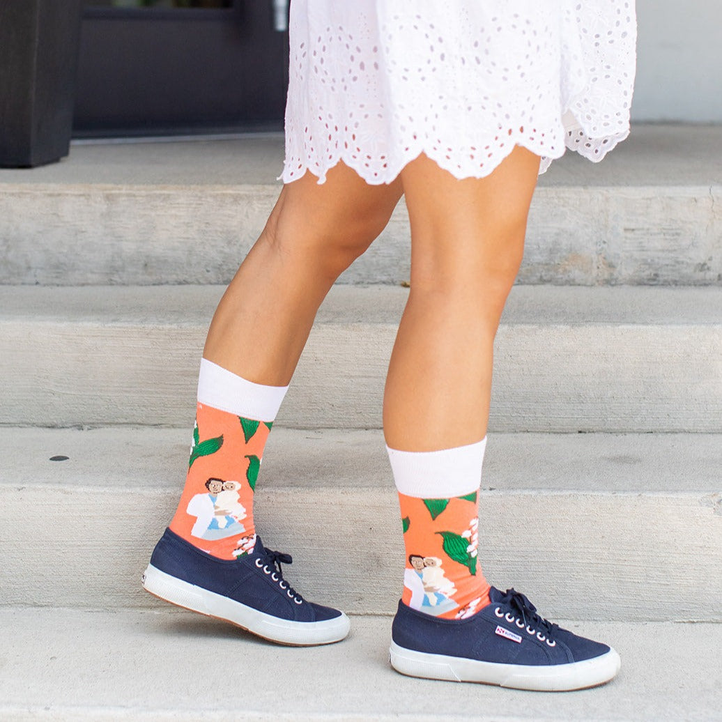 a woman wearing colorful socks and a white dress