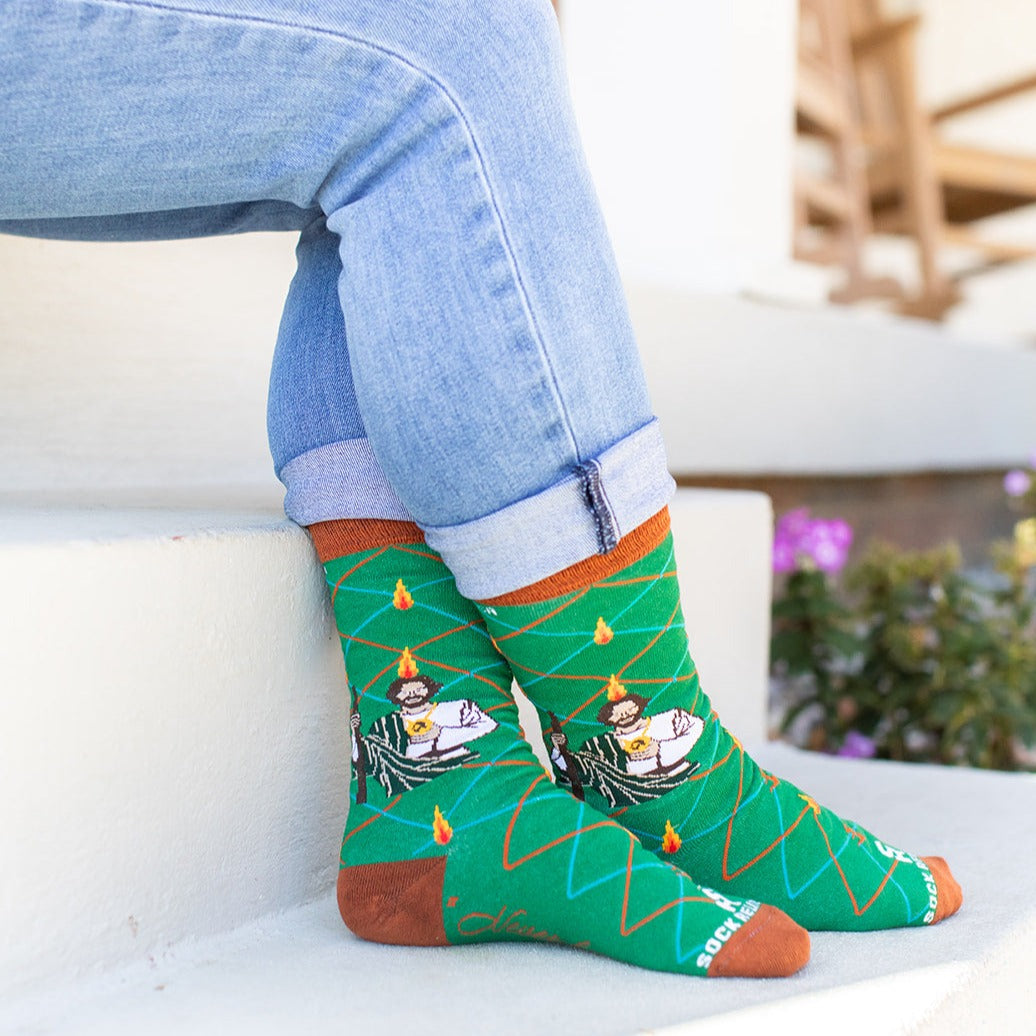 a person sitting on a step wearing a pair of socks with a picture of St. Jude