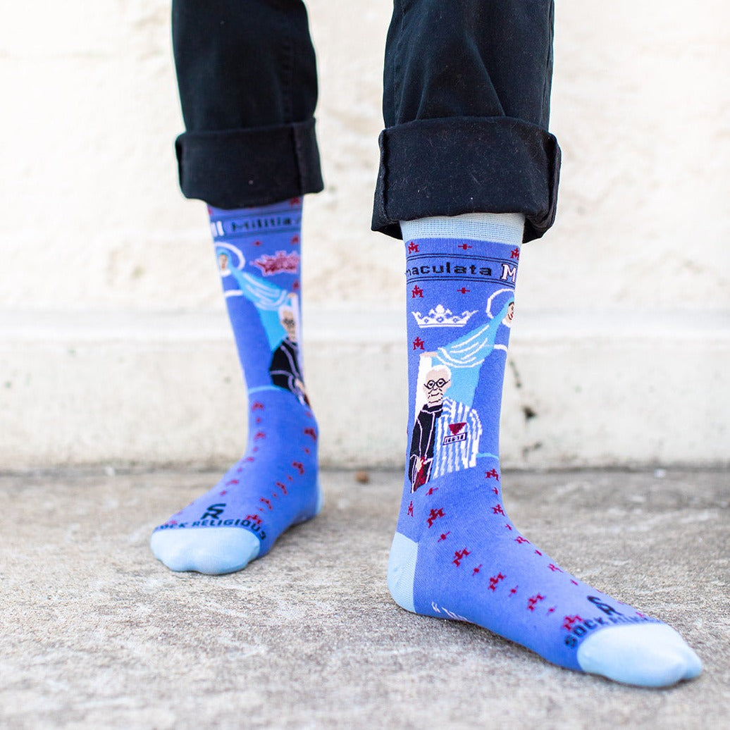 a person wearing a pair of blue socks with a picture of St. Maximilian Kolbe