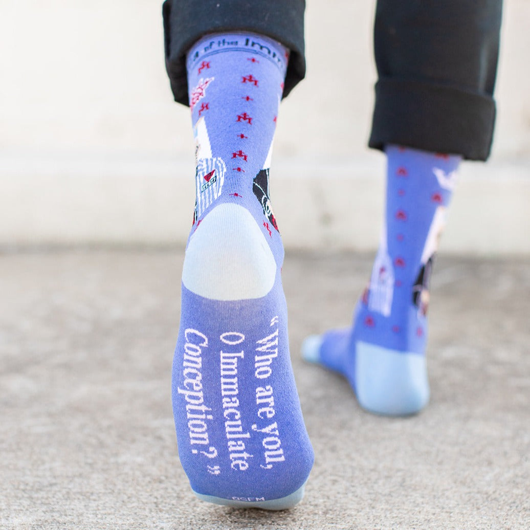 a person wearing a pair of blue socks with a picture of St. Maximilian Kolbe
