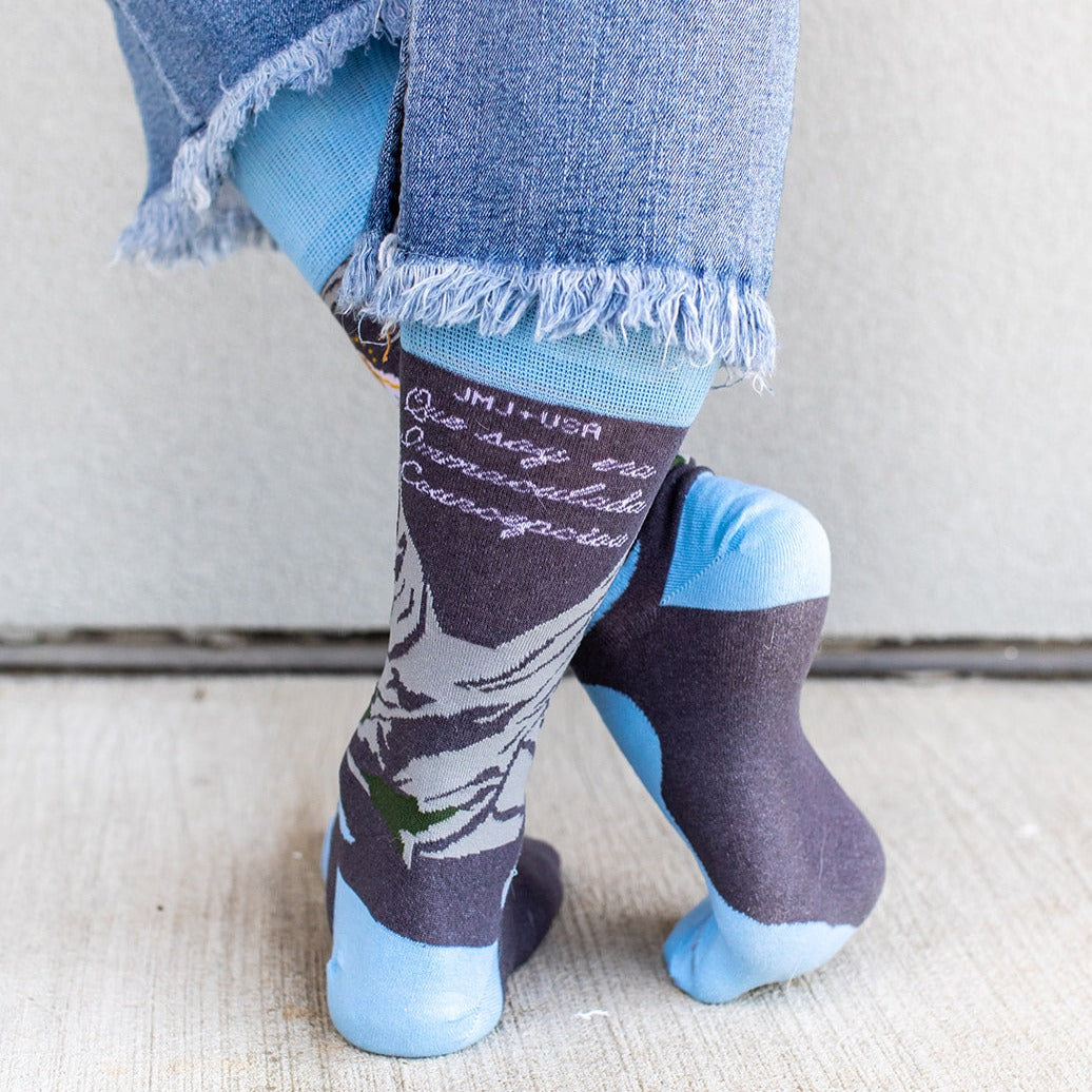 a person wearing a pair of socks with the image of Our Lady of Lourdes