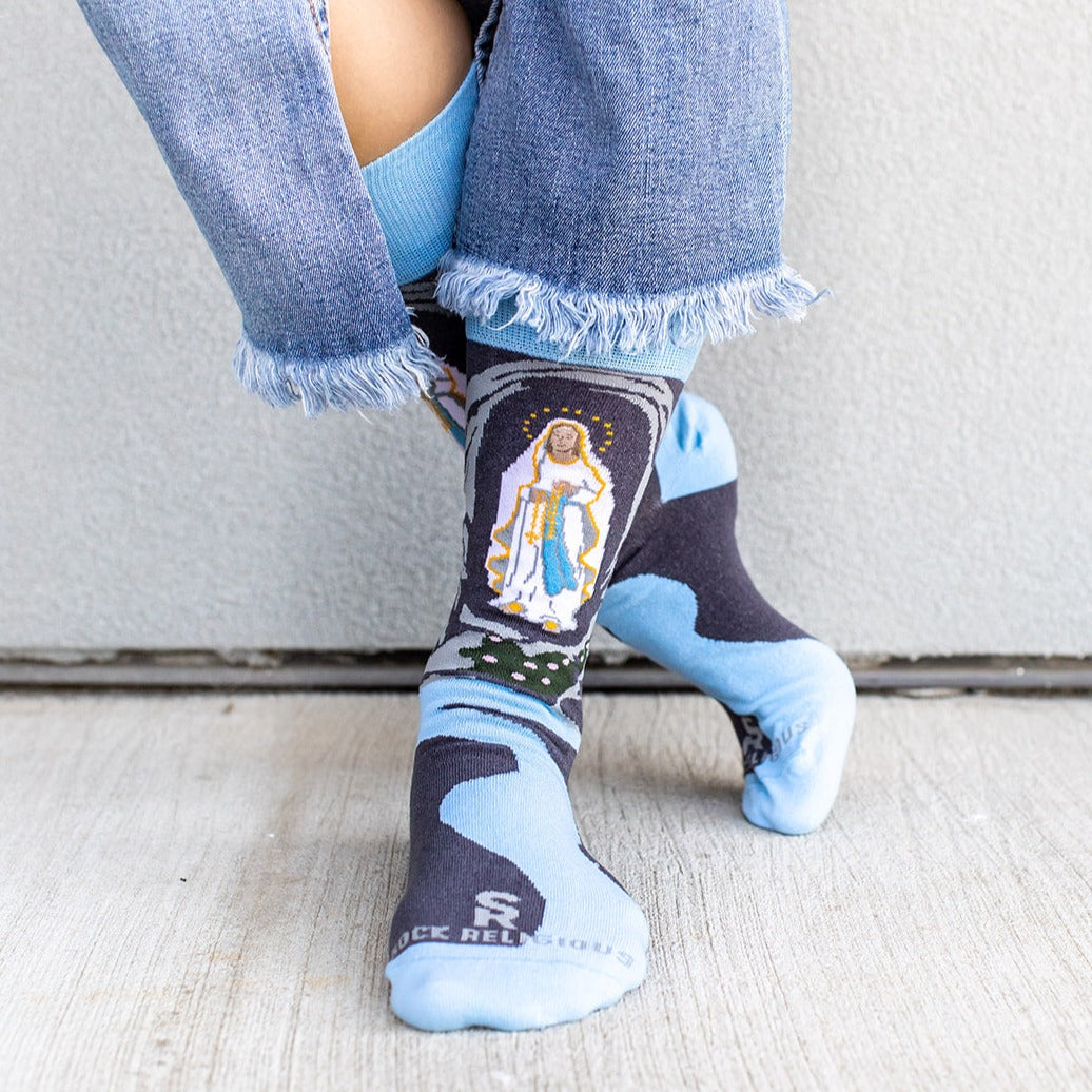 a person wearing a pair of socks with the image of Our Lady of Lourdes
