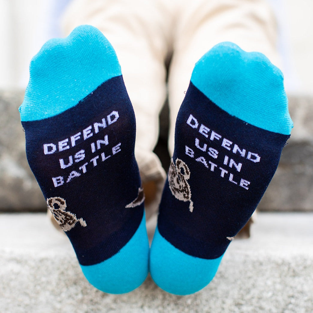 St. Michael socks that say defend us in battle on the bottom