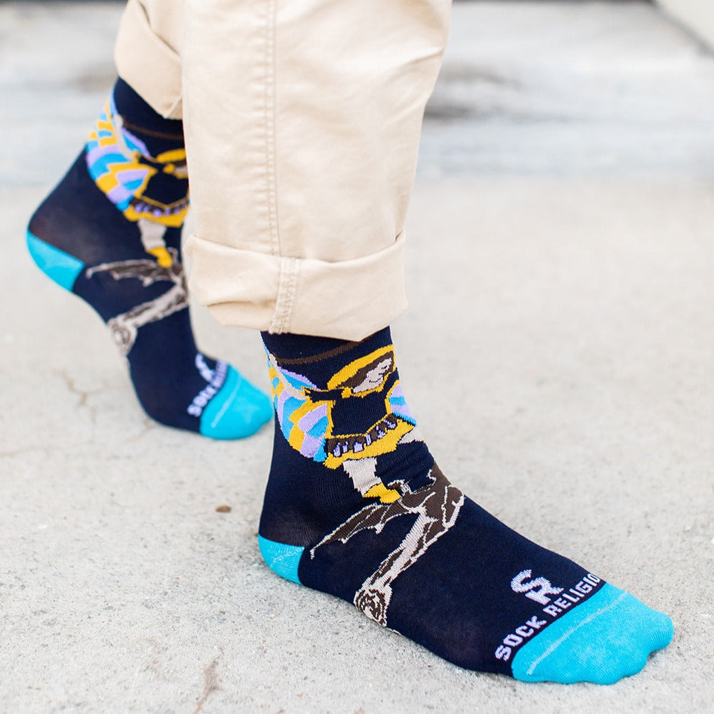 a person wearing a pair of socks with St. Michael slaying a demon