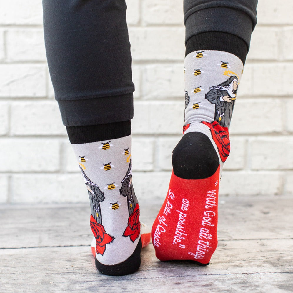a person wearing a pair of socks with a picture of St. Rita