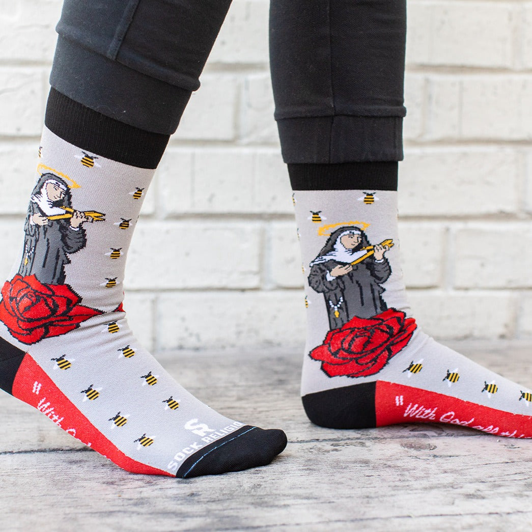a person wearing a pair of socks with a picture of St. Rita