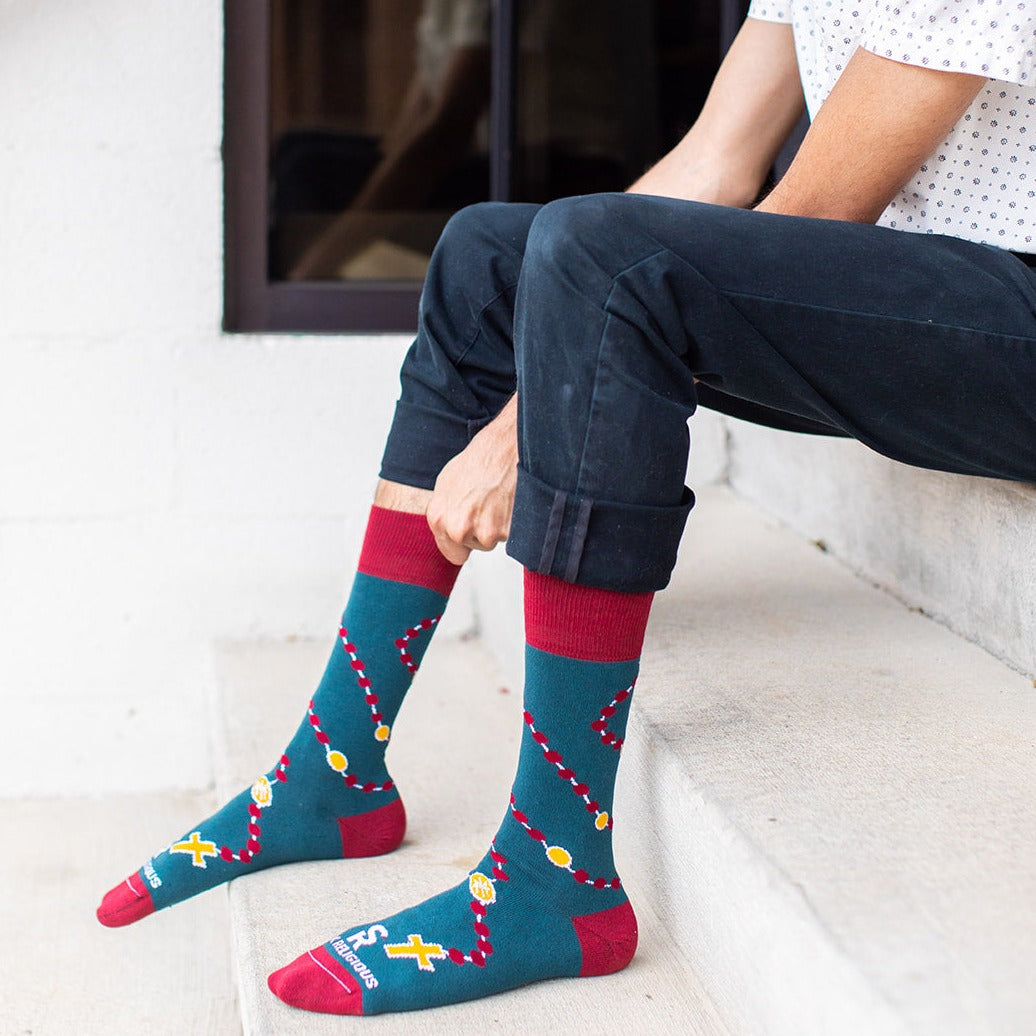 a man sitting on a step wearing a pair of socks with a design of rosary